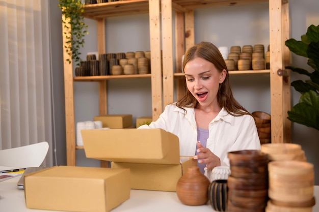 A young pretty woman entrepreneur checking and packaging craft products