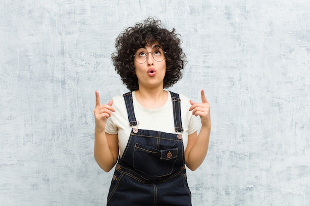 ショックと驚きの表情で上向きにa敬の念を感じて口を開けて若いきれいな女性