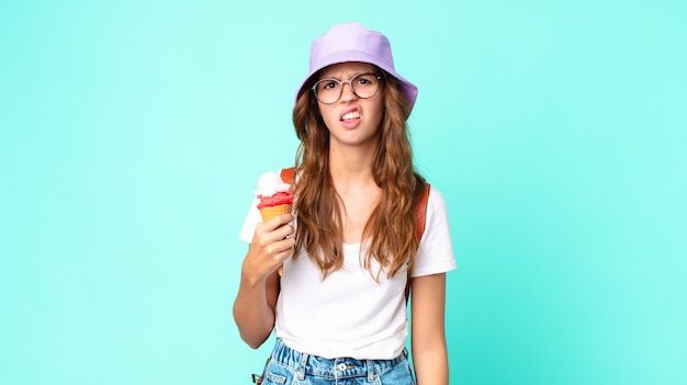 Young pretty woman feeling disgusted and irritated and tongue out holding an ice cream. summer concept