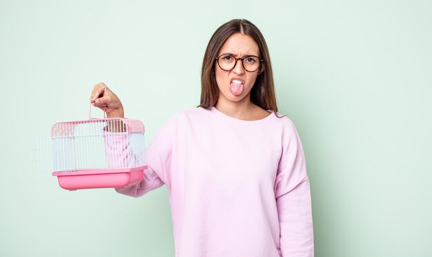 Young pretty woman feeling disgusted and irritated and tongue out. pet cage concept