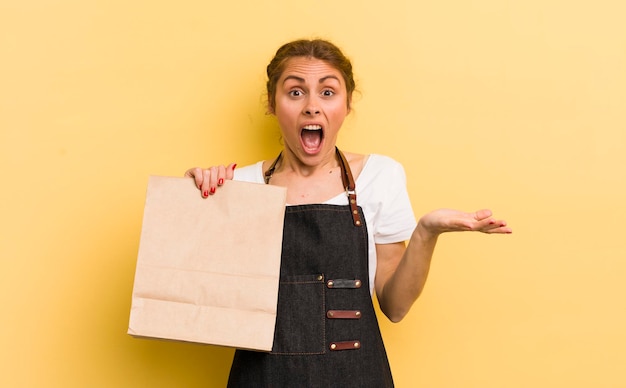 Young pretty woman feeling happy and astonished at something unbelievable fast food courier concept