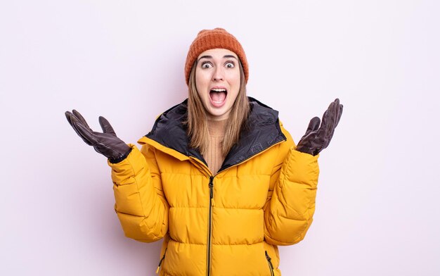 Young pretty woman feeling happy and astonished at something unbelievable. winter concept