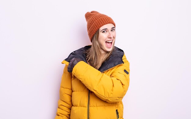 young pretty woman feeling happy and facing a challenge or celebrating. winter concept