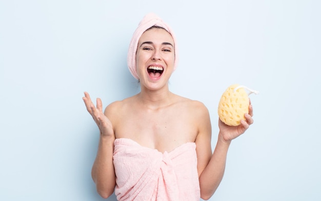 young pretty woman feeling happy, surprised realizing a solution or idea. shower and sponge concept