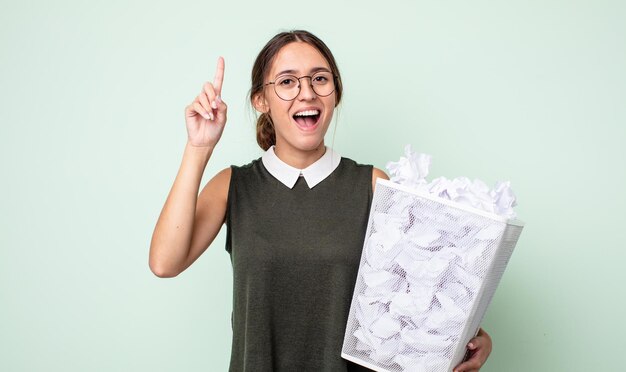 молодая красивая женщина чувствует себя счастливым и взволнованным гением после реализации идеи. концепция мусора из бумажных шариков