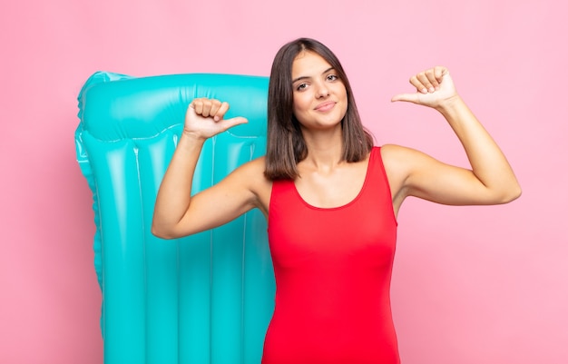 Foto giovane donna graziosa che si sente orgogliosa, arrogante e sicura di sé, che sembra soddisfatta e di successo, indicando se stessa