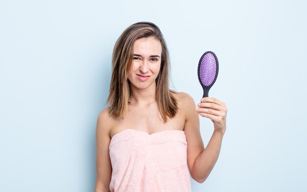 困惑と混乱を感じている若いきれいな女性。ヘアブラシのコンセプト