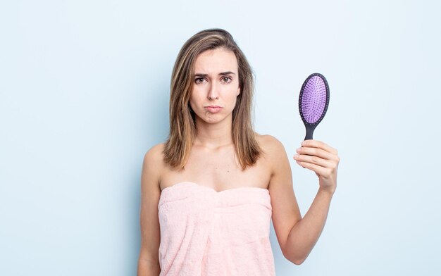 Giovane bella donna che si sente triste e piagnucolona con uno sguardo infelice e piange. concetto di spazzola per capelli