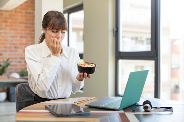 Foto giovane bella donna che si sente spaventata preoccupata o arrabbiata e guarda al concetto di ciotola di ramen laterale