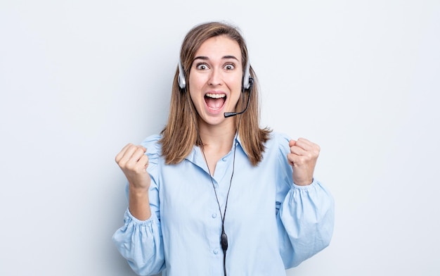 Young pretty woman feeling shocked,laughing and celebrating success. telemarketer concept