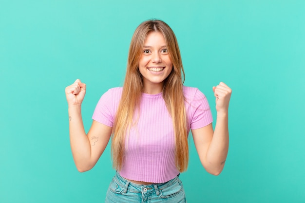 Young pretty woman feeling shocked,laughing and celebrating success