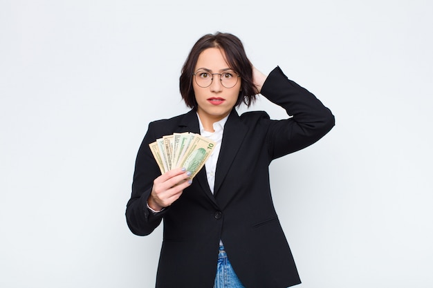 Foto giovane bella donna sentirsi stressata, preoccupata, ansiosa o spaventata, con le mani sulla testa, in preda al panico per errore con le bollette