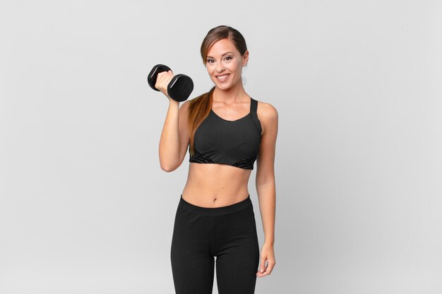 young pretty woman fitness concept and lifting a dumbbell