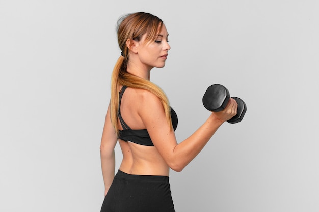 Young pretty woman fitness concept and lifting a dumbbell