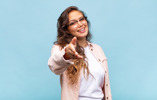 young pretty woman gesturing on blue wall