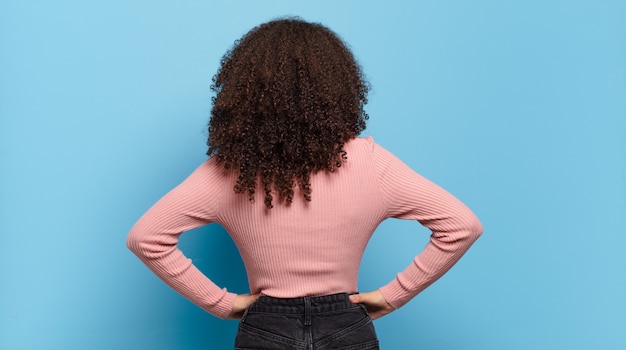 Foto giovane donna graziosa che gesturing sulla parete colorata