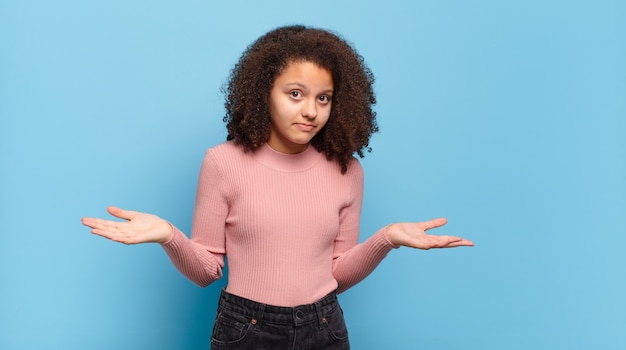 Young pretty woman gesturing on colored wall