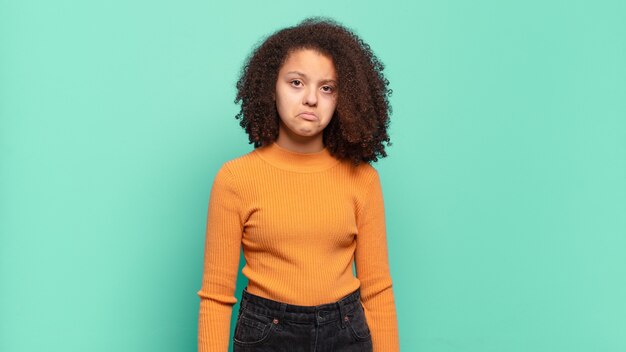 Young pretty woman gesturing on colored wall