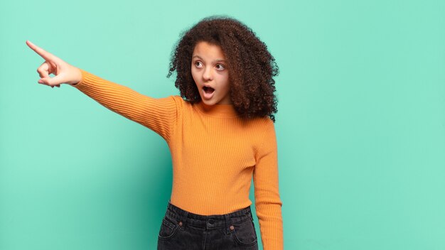 Young pretty woman gesturing on colored wall