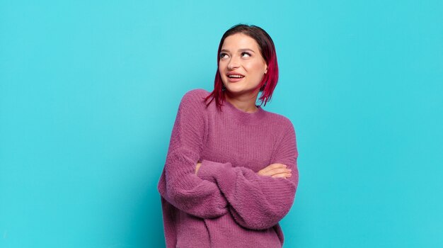 Young pretty woman gesturing on colored wall