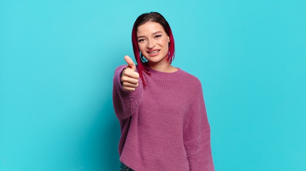 Young pretty woman gesturing on colored wall