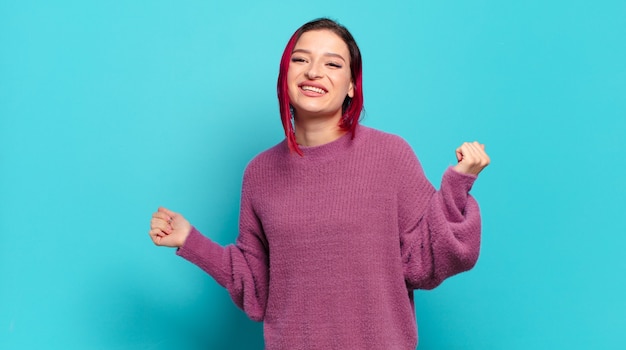 Young pretty woman gesturing on colored wall