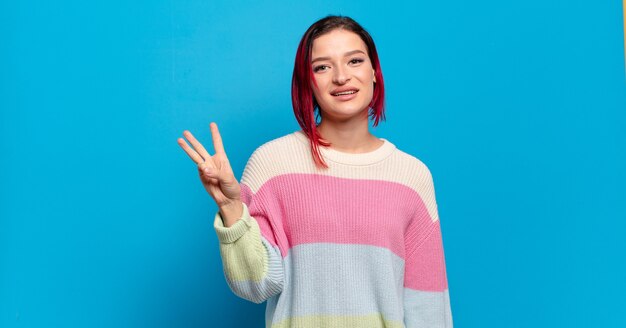 Young pretty woman gesturing on colored wall