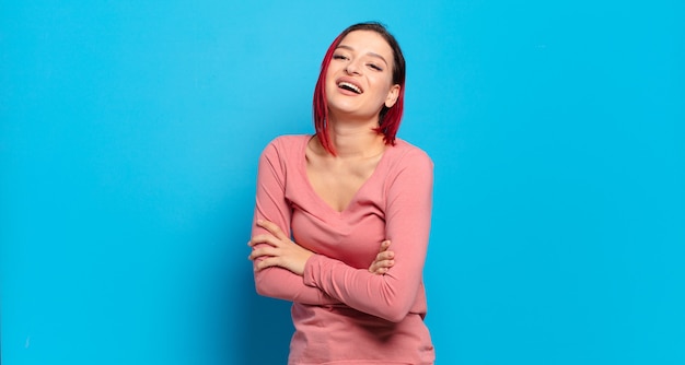 Young pretty woman gesturing on colored wall