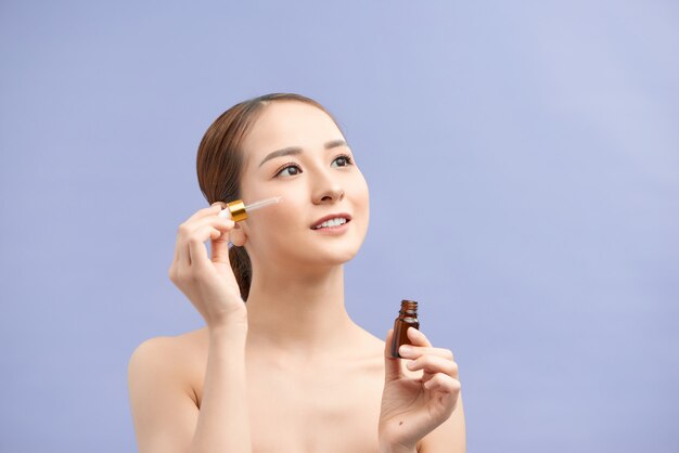 Young pretty Woman getting special skin treatment at beauty salon. Beautiful Girl applying eye serum