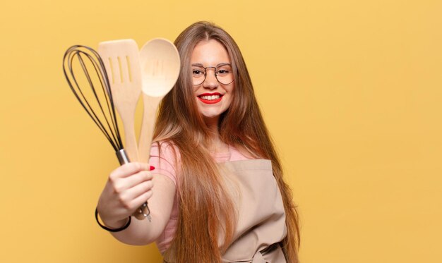 Giovane bella donna. concetto di cucina chef espressione felice e sorpresa