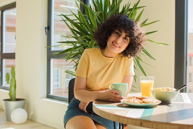 Foto giovane e bella donna facendo colazione a casa.