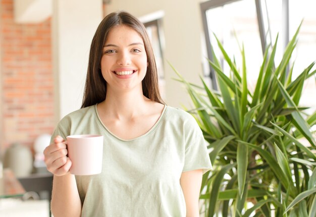 家でコーヒーを飲んでいる若いきれいな女性