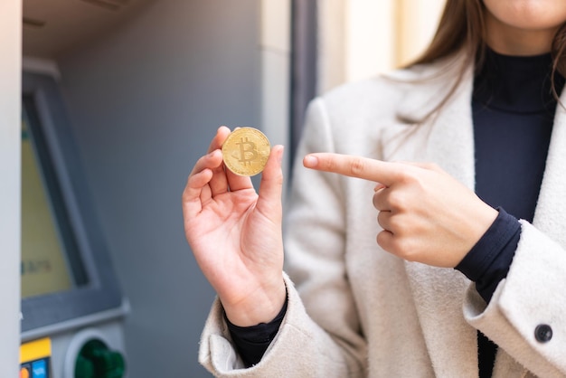 Young pretty woman holding a Bitcoin at outdoors