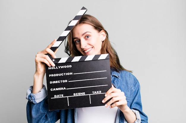 Young pretty woman holding a clapper cinema board