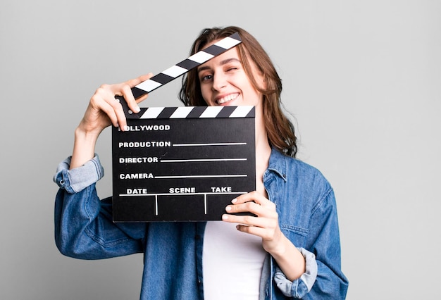 Young pretty woman holding a clapper cinema board