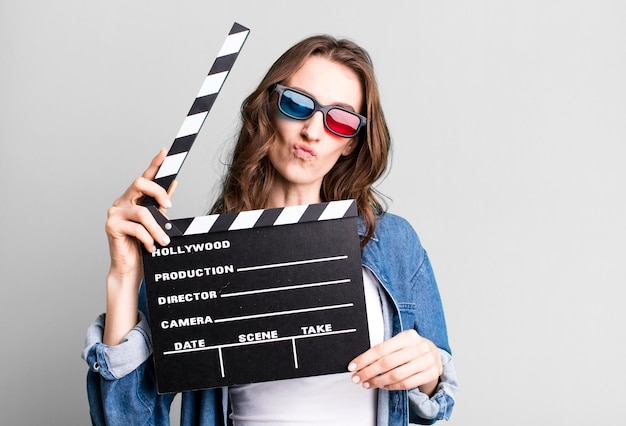 Young pretty woman holding a clapper cinema board