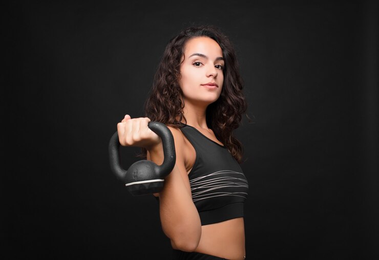 Photo young pretty woman holding a dumbbell