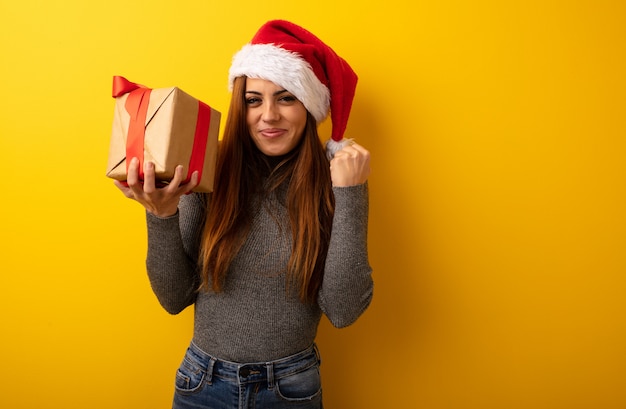 Young pretty woman holding gift surprised and shocked