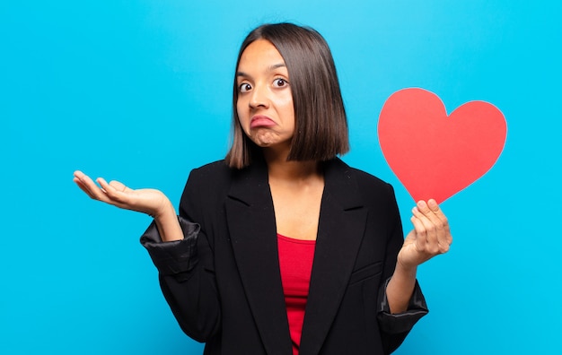 Young pretty woman holding a heart card