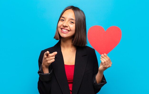 Young pretty woman holding a heart card