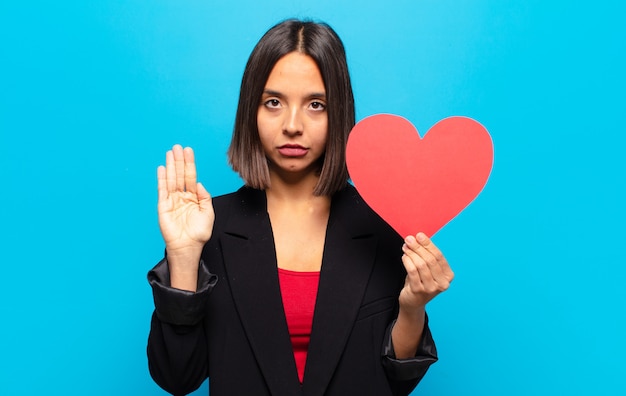 Young pretty woman holding a heart card