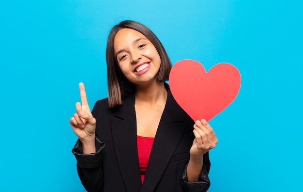 Young pretty woman holding a heart card