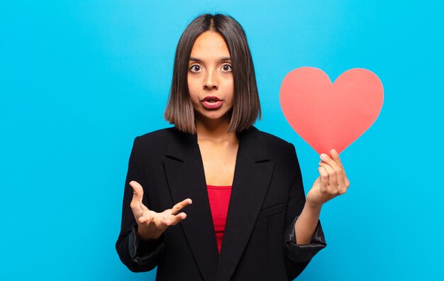 Young pretty woman holding a heart card