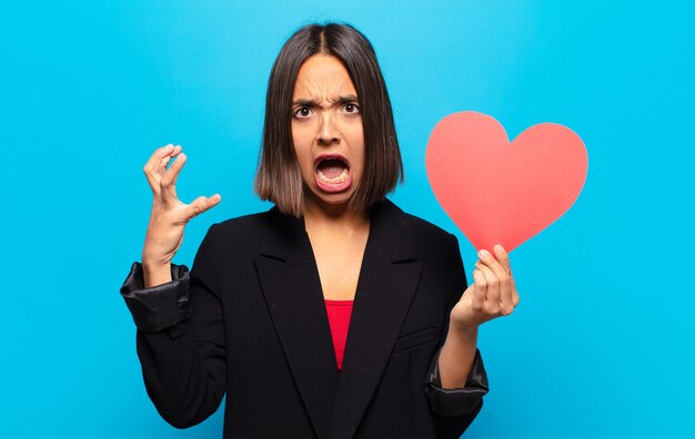 Photo young pretty woman holding a heart card