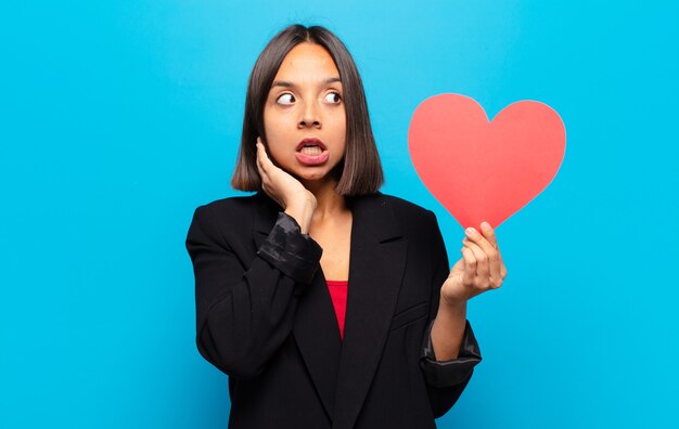 Young pretty woman holding a heart card