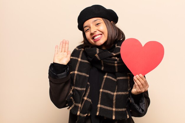 Photo young pretty woman holding a heart card