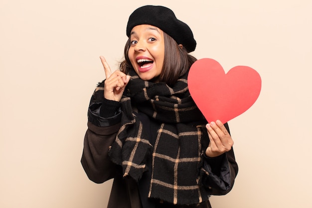 Young pretty woman holding a heart card