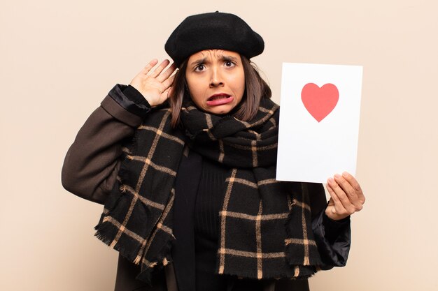 Young pretty woman holding a heart card