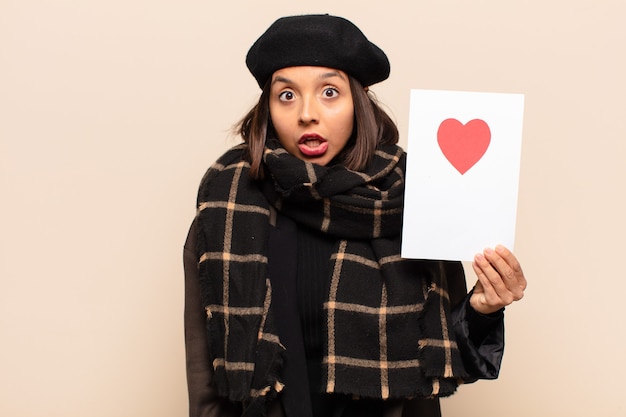 Young pretty woman holding a heart card