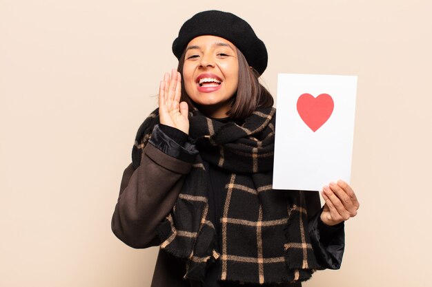 Young pretty woman holding a heart card